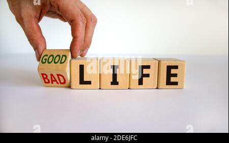Vom schlechten zum guten Leben. Hand dreht einen Würfel und ändert die Wörter "schlechtes Leben" zu "gutes Leben". Schöner weißer Hintergrund. Business and Good Life Konz Stockfoto