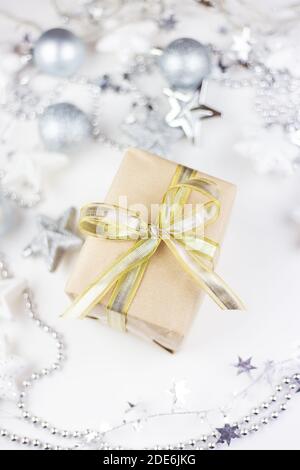 In der Mitte des sortierten Weihnachtsspielzeugs befindet sich eine goldene Geschenkbox aus Kraftpapier auf weißem Hintergrund Stockfoto