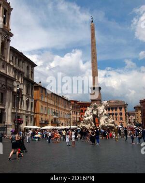 Ein vielbeschäftigter Markt auf der Piazza Navona in Rom, Italien, hinter dem sich im Zentrum der berühmte Brunnen der vier Flüsse befindet Stockfoto