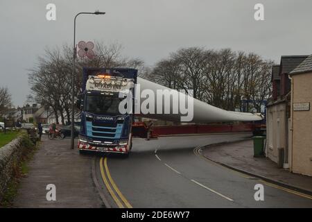 Ein LKW, der ein Turbinenblatt für einen Windpark transportiert Auf der Straße durch das Dorf Golspie in der Schottische Highlands Stockfoto