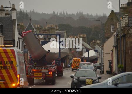 Ein LKW-Konvoi, der Turbinenschaufeln für einen Wind transportiert Bauernhof an der Hauptstraße durch das Dorf Golspie In den schottischen Highlands Stockfoto