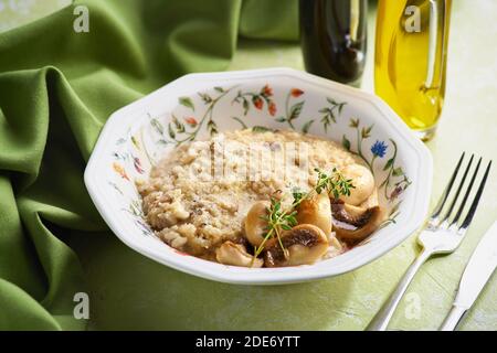 Schüssel Pilzrisotto garniert mit Thymianblättern, selektiver Fokus Stockfoto