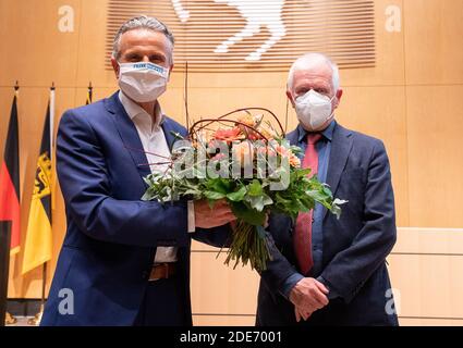 Stuttgart, Deutschland. November 2020. Frank Nopper (CDU), Kandidat der CDU und Sieger der Oberbürgermeisterwahl, steht im Rathaus neben Fritz Kuhn (Bündnis 90/die Grünen), Oberbürgermeister von Stuttgart, nach der Wahl des neuen Oberbürgermeisters von Stuttgart mit einem Blumenstrauß in der Hand. Quelle: Sebastian Gollnow/dpa/Alamy Live News Stockfoto