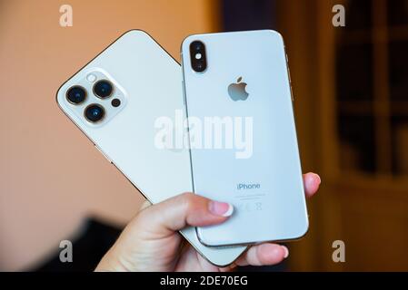 Prag, Tschechische republik - 24. November 2020. Neues iPhone 12 Pro Max und altes iPhone X in kleiner Frauenhand Stockfoto
