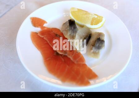 Scheiben Lachs und Hering auf dem Teller Stockfoto