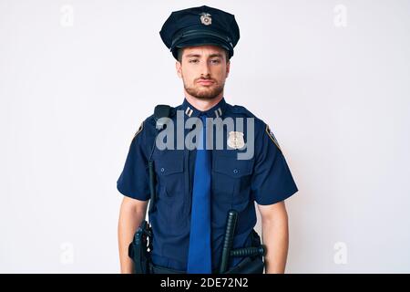 Junger Kaukasier in Polizeiuniform, müde und müde, erschöpft von Müdigkeit und Kater, faule Augen am Morgen. Stockfoto