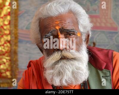 Würdevoller alter indischer Hindu-Anhänger und Pilger mit gut präparierten weißen Haaren und Vollbart-Posen für die Kamera während Shivratri Mela (Bhavnath Fair). Stockfoto