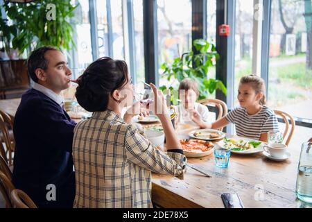 Eine vierköpfige Familie, die in einem Café zu Abend gegessen hat. Stockfoto