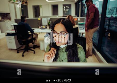 Portrait der schönen Geschäftsfrau konzentriert sich während der Arbeit an Bericht Essay Tippen auf dem Schreibtisch sitzen im Büro Stockfoto