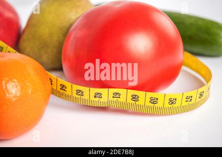 Stillleben: Gemüse und Obst, und ein Zentimeter in ihrer Nähe auf einem hellen Hintergrund. Gesunde Ernährung Stockfoto