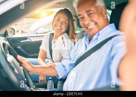 Mittelalterpaar verliebt sitzt im Auto gehen Für eine Reise, die ein Selfie-Bild mit Smartphone lächelt Glücklich und fröhlich zusammen Stockfoto