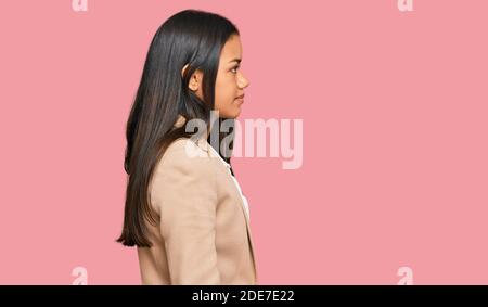 Schöne hispanische Frau trägt Business Jacke suchen zur Seite, entspannen Profil Pose mit natürlichen Gesicht mit selbstbewussten Lächeln. Stockfoto