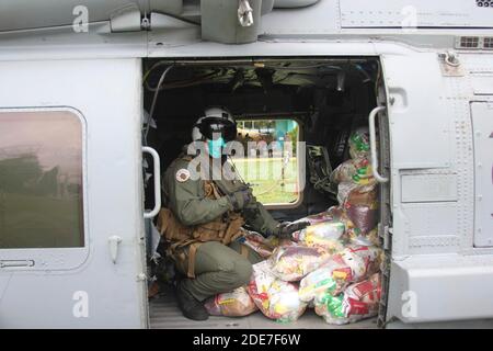 Ein Seemann der US-Marine bereitet sich darauf vor, humanitäre Hilfsgüter aus einem Sea Hawk Hubschrauber zu entladen, um nach dem Hurrikan Iota am 23. November 2020 in Soto Cano, Honduras, zu helfen. Zurück zu hinten die Hurrikane Eta und Iota fegten durch Mittelamerika und zerstörten große Teile der Küste und überschwemmten Straßen. Stockfoto