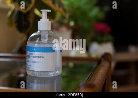Handdesinfektionsflasche auf einem Tisch im Wohnzimmer mit weichem Fokus Hintergrund Stockfoto