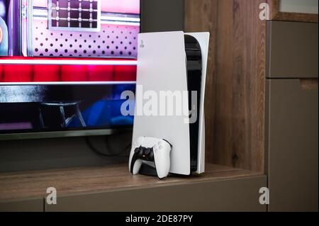 Moskau - November 28 2020: Die brandneue Sony PlayStation 5 Spielkonsole mit DualSense-Controller in der Nähe des fernsehbildschirms zu Hause einsatzbereit. Stockfoto