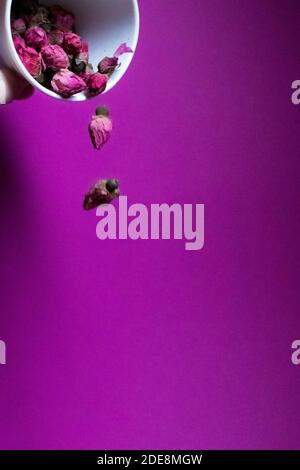 Eine Menge von kleinen rosa Rosen fallen auf einem rosa Hintergrund - vertikales Foto Stockfoto