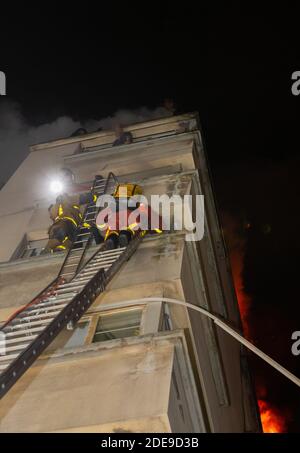 Dieses Handout-Foto, das in der Nacht vom 5. Februar 2019 von der Pariser Feuerwehr (BSPP) aufgenommen und veröffentlicht wurde, zeigt Feuerwehrleute, die Bewohner retten, als in einem Gebäude in der Erlanger Straße im 16. Arrondissement in Paris ein Feuer brennt. Eine Frau wurde wegen eines tödlichen Brandes, bei dem acht Menschen in Paris ums Leben kamen, verhaftet, und die Polizei behandelt das Feuer als möglichen Brandanschlag, sagte ein Staatsanwalt am 5. Februar. Foto von Benoit Moser/BSPP - Brigade de sapeurs-pompiers de Paris/ABACAPRESS.COM Stockfoto