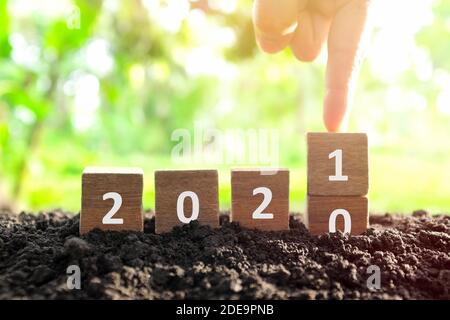 Männliche Hand begraben Jahr 2020 auf 2021 in Holzklötze Würfel ändern. Neujahr, Hallo und Auf Wiedersehen Konzept. Stockfoto