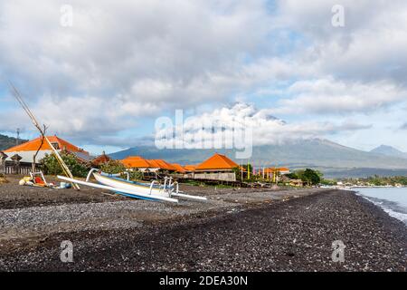 Blick auf den Agung Vulkan aus dem Ozean. Dörfer, Häuser, Boote jukung um. Amed, Karangasem Regency, Bali, Indonesien Stockfoto