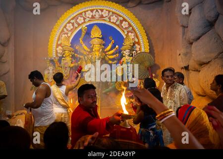 Kolkata, Indien - 17. Oktober 2018 : hinduistische weibliche Anhänger, die ihre Hände ausdehnen, um die Wärme der heiligen Lampe während Sandhi Puja zu erhalten, als hinduistisches Ritual f Stockfoto