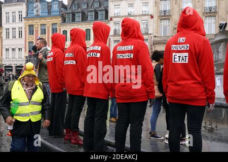 Demonstranten, die einen dreifarbigen Kakadus auf ihrer Kapuze tragen, ein Emblem, das sich auf die Französische Revolution bezieht, stehen mit aufgeklebtem Mund während einer regierungsfeindlichen Demonstration, die von der Bewegung "Gelbe Weste" (Gilets Jaunes) in der nordfranzösischen Stadt Lille am 2. März 2019 aufgerufen wurde. Die Organisatoren der Demonstration riefen Demonstranten aus Nachbarländern wie Belgien, Großbritannien, den Niederlanden, Luxemburg und Deutschland dazu auf, sich in Richtung Lille zu "konvergieren". Foto von Sylvain Lefevre/ABACAPRESS.COM Stockfoto