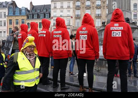 Demonstranten, die einen dreifarbigen Kakadus auf ihrer Kapuze tragen, ein Emblem, das sich auf die Französische Revolution bezieht, stehen mit aufgeklebtem Mund während einer regierungsfeindlichen Demonstration, die von der Bewegung "Gelbe Weste" (Gilets Jaunes) in der nordfranzösischen Stadt Lille am 2. März 2019 aufgerufen wurde. Die Organisatoren der Demonstration riefen Demonstranten aus Nachbarländern wie Belgien, Großbritannien, den Niederlanden, Luxemburg und Deutschland dazu auf, sich in Richtung Lille zu "konvergieren". Foto von Sylvain Lefevre/ABACAPRESS.COM Stockfoto