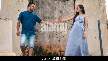 Zwei schöne Modelle, ein junges Ehepaar, Mutter zu schwangere Dame, Hände halten, und einander an einer alten Wand stehend, portr Stockfoto