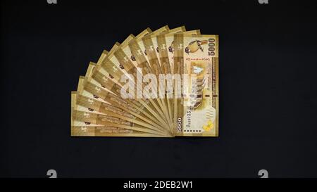 5000 Sri Lanka Rupie Noten Stapel auf einem schwarzen Hintergrund. Machen einen Viertelkreis, gelb goldene Farbe Bills Muster. Stockfoto