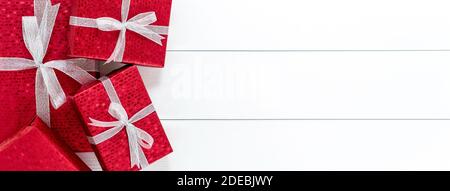 Gruppe von roten Weihnachtsgeschenkboxen auf weißem Holz Banner Hintergrund Rahmen Design mit Kopieplatz Stockfoto