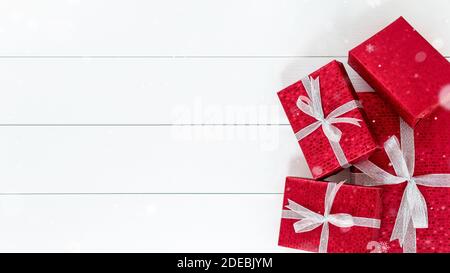 Gruppe von roten Weihnachtsgeschenkboxen am Rand von weiß Holzplatte Hintergrund mit Kopierraum Stockfoto