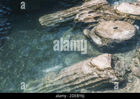 Historischer Kleopatra-Pool und antike Ruinen in der antiken Stadt Hierapolis. Pamukkale (Cotton Castle), Denizli, Türkei. Stockfoto