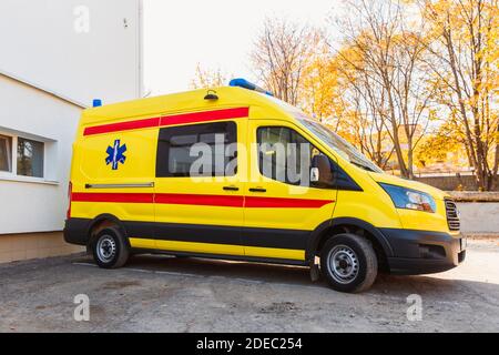 Zaporozhye/Ukraine- November 08 2019 :Gelber Krankenwagen steht in der Nähe des Krankenhausgebäudes.Seitenansicht eines Autos. Krankenwagen das Auto kostet warten Stockfoto