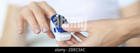 Der Arzt fixiert den Herzfrequenzsensor am Finger Stockfoto