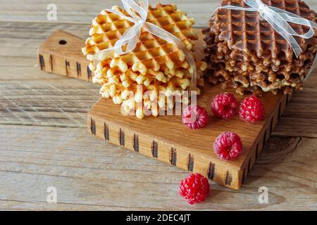 Heiße belgische Waffeln mit Himbeeren auf Schneidebrett Stockfoto