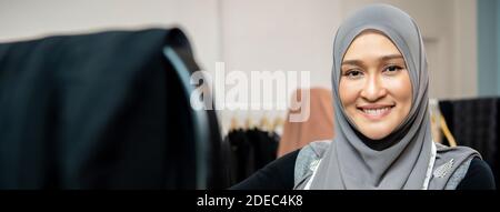 Asiatische muslimische Frau Designerin als Startup-Geschäft Inhaber in ihrem Schneider-Shop, Panorama-Web-Banner Stockfoto