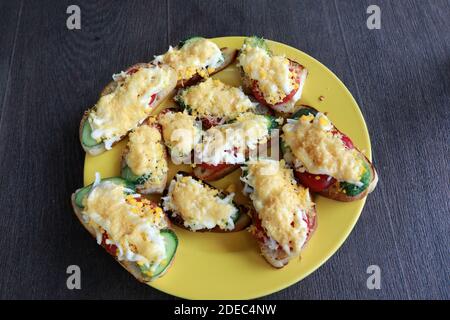 Sandwiches mit verschiedenen Füllungen auf gelbem Teller Stockfoto