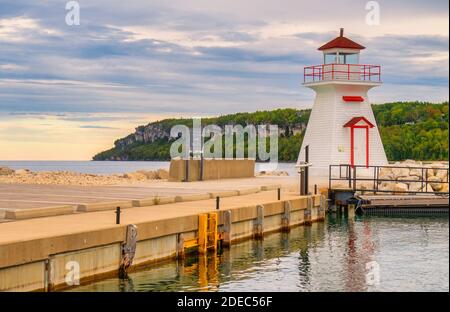 Lion's Head Leuchtturm im Hafen mit der Kalksteinklippe im Lion's Head Provincial Park von Ontario im Hintergrund. Der Leuchtturm wurde später Stockfoto