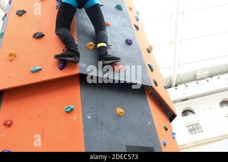 Person Training an Kletterwand in der Turnhalle Stockfoto