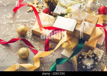 Stapel von glitzernden Silber und Gold Weihnachtsgeschenkboxen mit Bunte Bänder und Dekorationsartikel auf dem Tisch Stockfoto