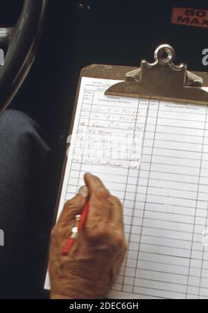 Der Fahrer notiert seine nächste Abholadresse auf einem Dial A Ride Radio, das in Haddonfield einen Tür-zu-Tür-Bus-Service abstellt; New Jersey. Ca. 1974 Stockfoto