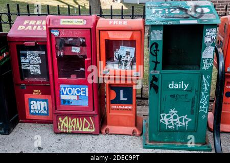 Kostenlose Zeitungsstände / Verkaufsboxen am Zaun des Fort Greene Park, Brooklyn, New York, USA. Die Stimme Des Dorfes. AM New York. Das L Magazin.