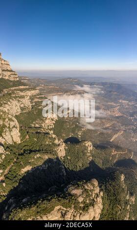 Luftdrohnenaufnahme von Montserrat Bergklippe mit Nebel in Morgen in der Nähe von Barcelona Stockfoto