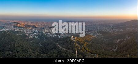 Panorama Luftdrohne Aufnahme des Tibidabo Berges mit Blick auf die Stadt Von Barcelona bei Sonnenuntergang Stockfoto