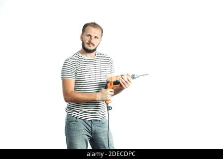 Ein bärtiger Mann in einem gestreiften T-Shirt hält ein Elektrowerkzeug in den Händen. Isoliert auf weißem Hintergrund. Stockfoto