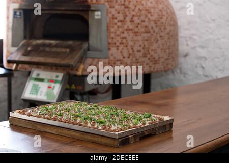 Vorbereiten und Backen einer Focaccia Pizza mit Tomatenmark und Käse Stockfoto