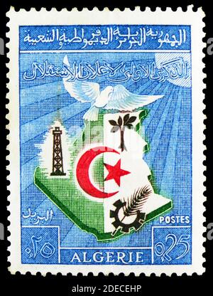 MOSKAU, RUSSLAND - 17. OKTOBER 2020: Briefmarke gedruckt in Algerien zeigt Karte und Emblem, 1. Jahrestag der Unabhängigkeit Algeriens Serie, um 1963 Stockfoto