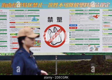 Haikou, China. November 2020. Ein Student der Universität geht an einem Plakat vorbei, das Plastiktüten in Haikou verbietet.ab dem 1. Dezember wird das chinesische Hainan die Herstellung, den Verkauf und die Verwendung einer breiten Palette von Einweg-Plastikprodukten verbieten, so die regionale Ökologie. Kredit: SOPA Images Limited/Alamy Live Nachrichten Stockfoto