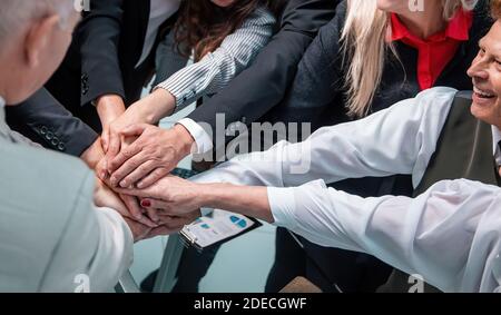 Nahaufnahme. Glückliche Gruppe von Mitarbeitern, die einen Stapel Hände machen. Stockfoto