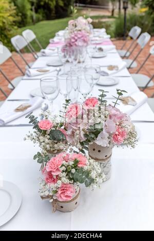 Hochzeitstisch mit Blumenstrauß und Weingläsern dekoriert. Stockfoto