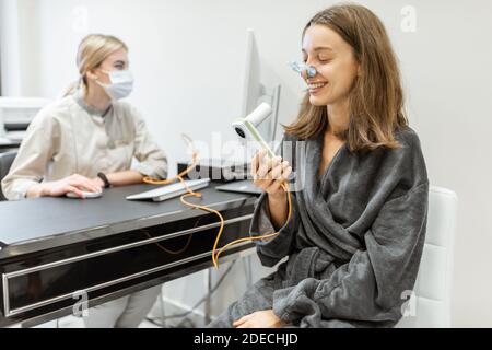 Junge Frau mit Arzt während einer Spirographie-Test, Messung der Atembewegungen mit Spirometer im Medical Spa Salon Stockfoto